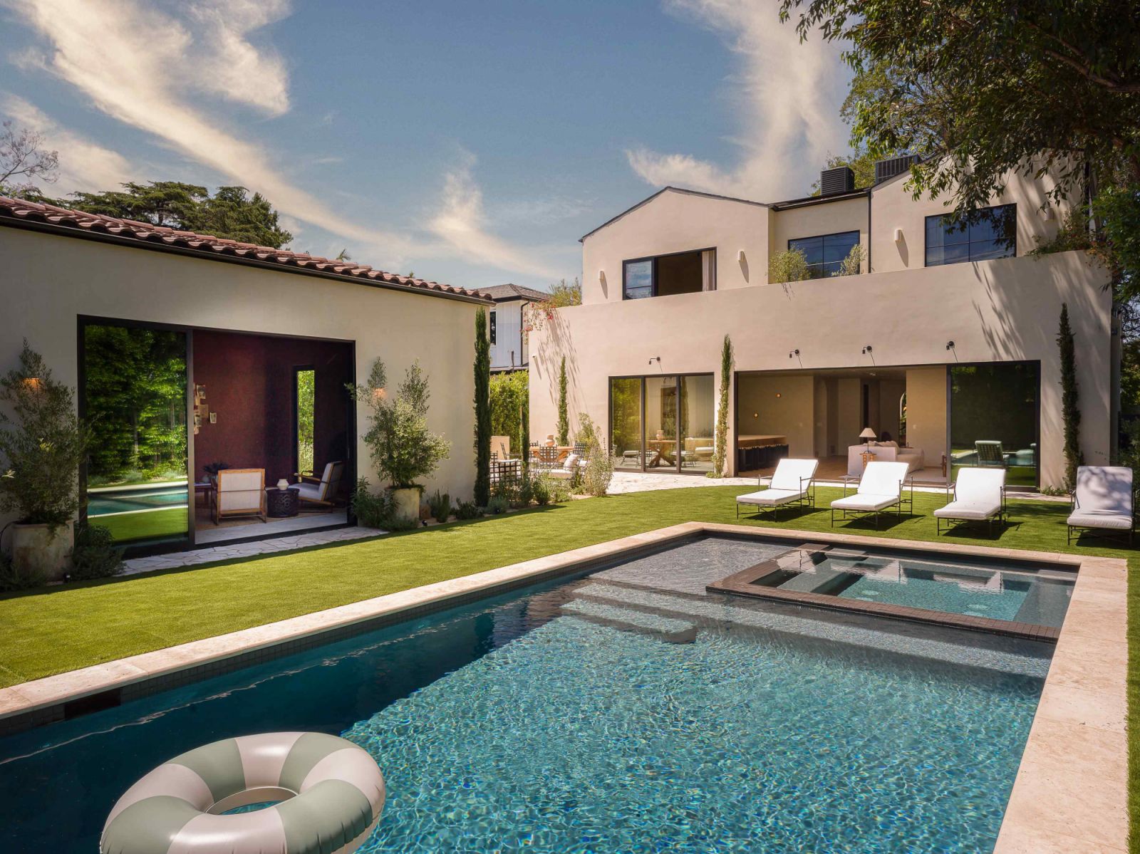 The sprawling backyard with a swimming pool and pool house