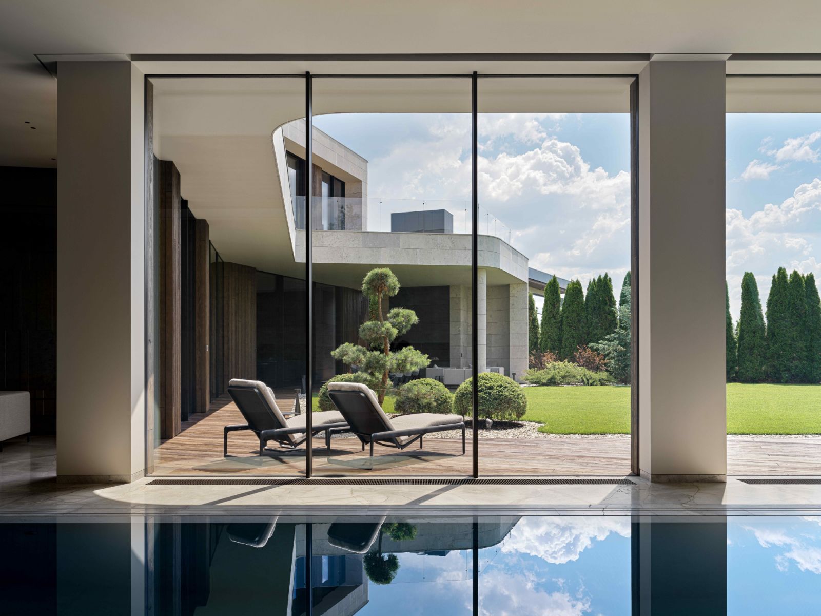 Panoramic metal-framed glass windows offer views of the lush courtyard