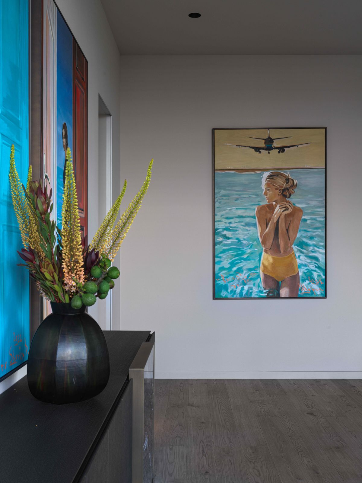 Curated artworks offer a vibrant relief from the monochromatic design theme