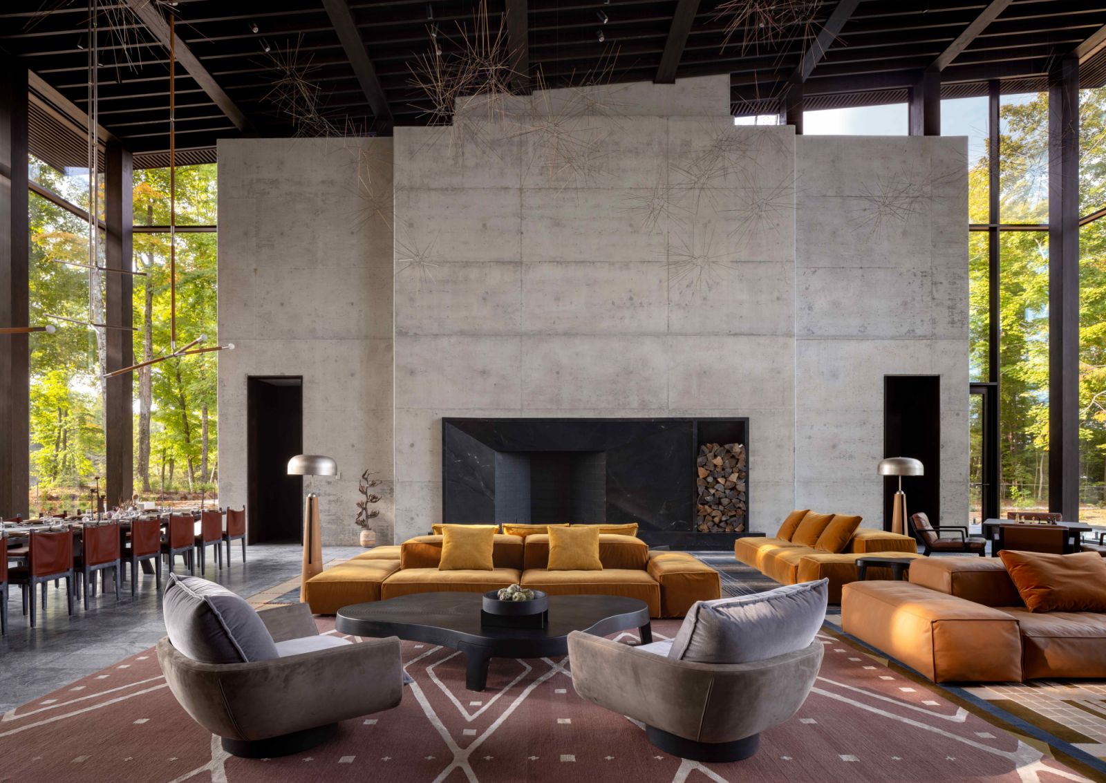 Monolithic concrete walls anchor the grand double-volume living room with grounding earthy-coloured furnishings