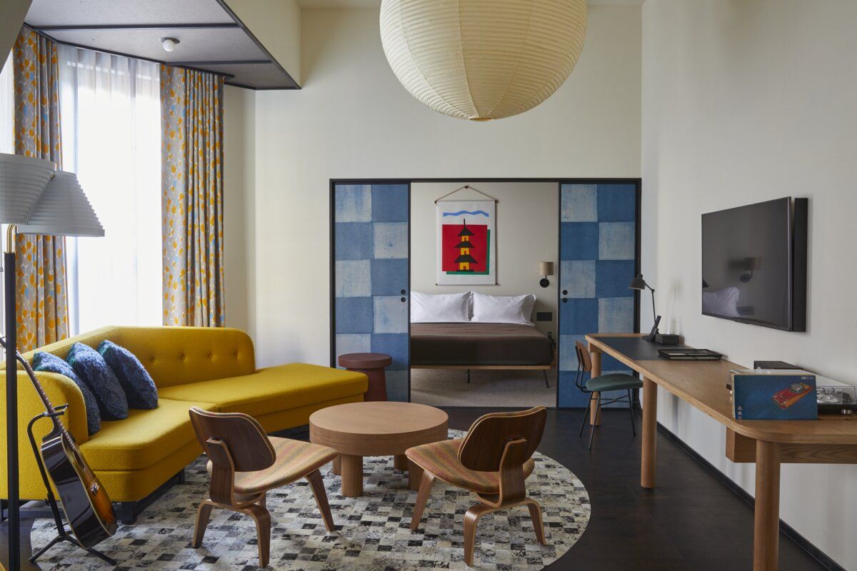 Open-plan accommodation at Ace Hotel Kyoto featuring Eames plywood chairs, custom Japanese textiles, and iconic Akari lighting fixtures by Isamu Noguchi. (Photo: Ace Hotel Kyoto)
