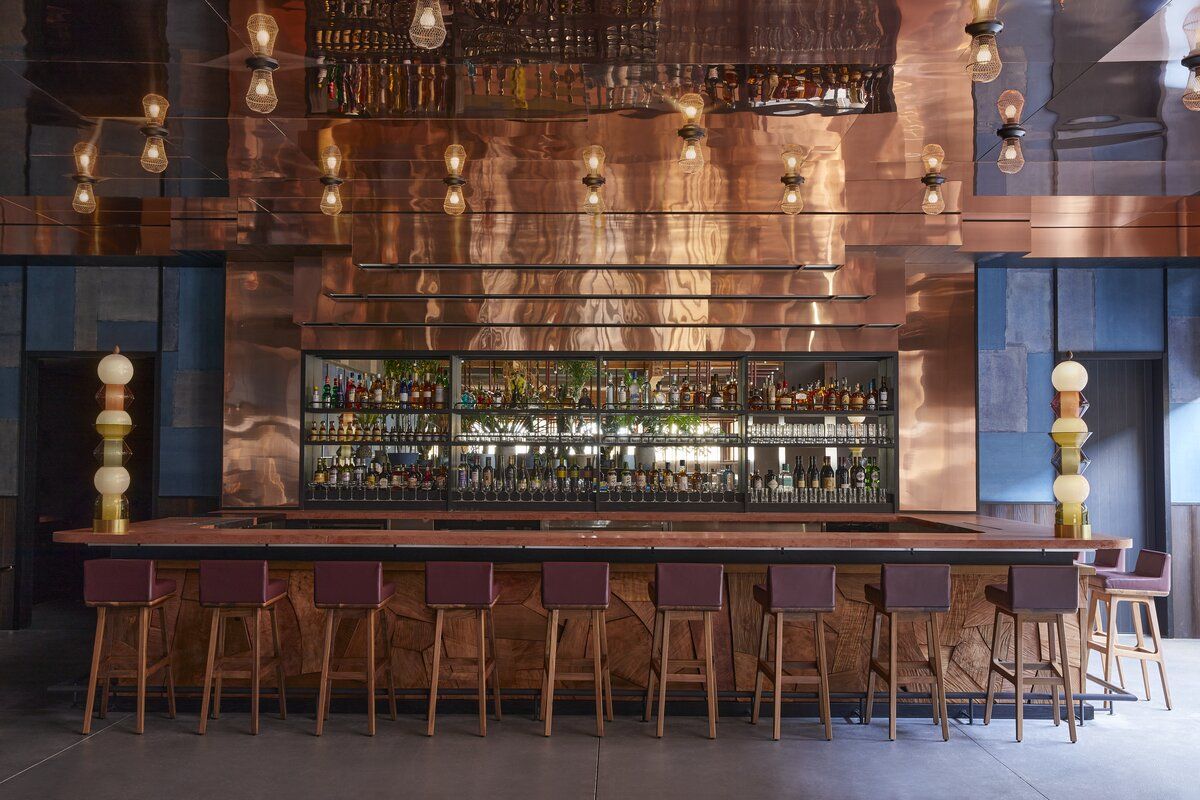 Copper-clad bar at Ace Hotel Kyoto featuring handcrafted pendant lighting and modernist seating—a contemporary interpretation of mid-century Japanese design(Photo: Ace Hotel Kyoto)