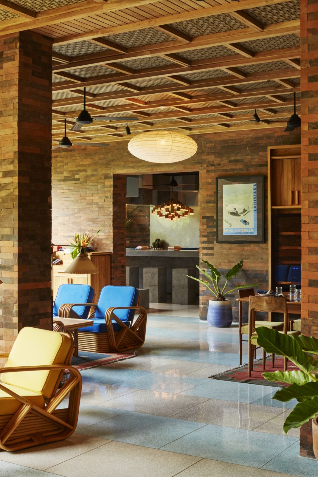Katamama Bali’s lobby lounge with patterned wooden ceiling coffers, Noguchi-inspired paper lanterns, and traditional Indonesian rattan furniture that creates dialogue between modernist forms and local materials (Photo: Katamama Bali)