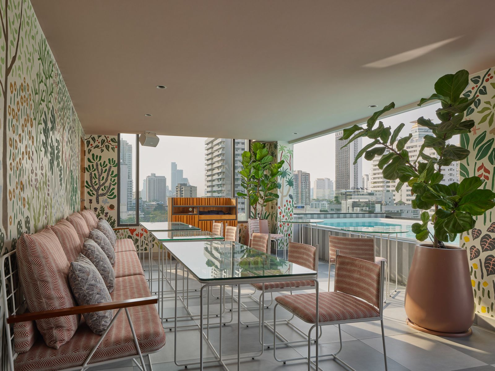Botanical-patterned dining terrace at Public House Hotel Bangkok offering panoramic city views, featuring modernist furniture and illustrated wallcoverings that reference Thailand's lush natural environment  (Photo: Public House Hotel Bangkok)