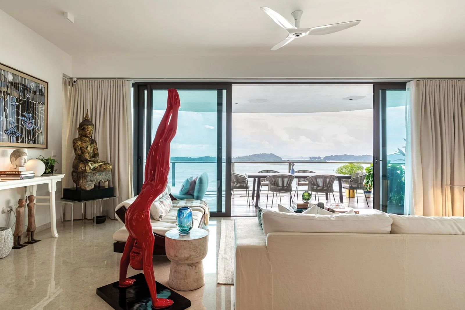 A sculpture by Chinese artist Chen Wen Ling makes a compelling statement in the living room of this Sentosa apartment with its bright red hue