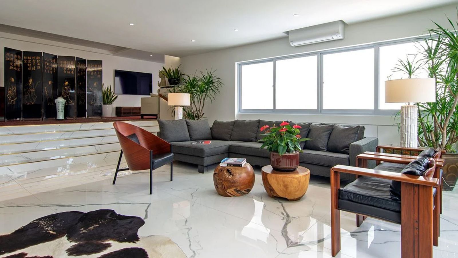 KNQ Associates opted to bookmatch the large-format floor tiles to create a seamless look in the freehold condo’s living room