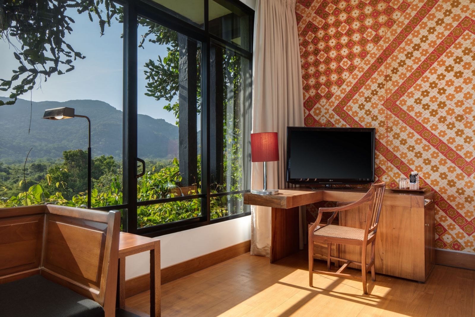 Guest room at Heritance Kandalama featuring traditional Sri Lankan textile wall coverings, abundant natural light, and wooden furniture—illustrating Bawa’s masterful blend of local craftsmanship with modernist simplicity  (Photo: Heritance Kandalama)