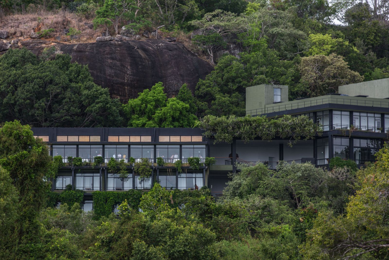Heritance Kandalama by Geoffrey Bawa nestled into Sri Lankan hillside, showcasing the architect’s signature integration of modernist structure with natural landscape—the building appears to emerge organically from its rocky surroundings  (Photo: Heritance Kandalama)