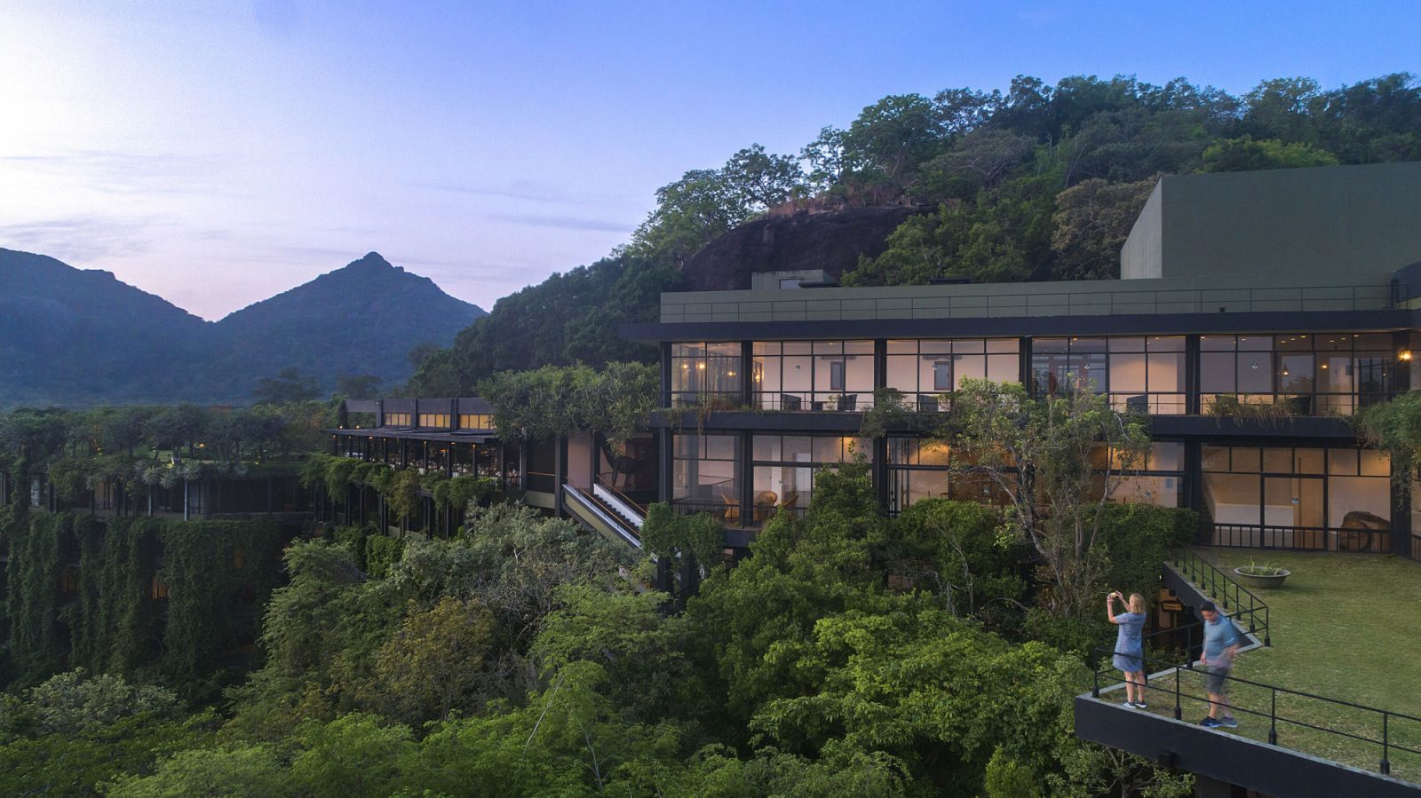 Dusk view of Heritance Kandalama highlighting its seamless connection between architecture and environment, with floor-to-ceiling glass framing dramatic mountain vistas—a hallmark of Bawa’s climate-responsive design approach  (Photo: Heritance Kandalama)