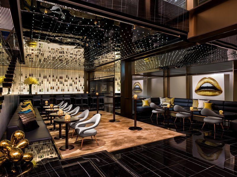 The cocktail bar at The Murray Hong Kong with mirrored ceiling, contemporary furnishings, and glamorous metallic accents—illustrating how the 1960s modernist structure has been reinvented with luxurious contemporary details (Photo: The Murray)