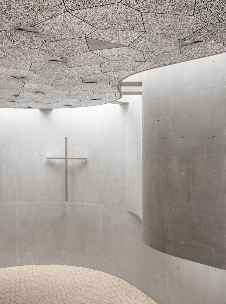 Detail of the church ceiling showing the innovative pentagonal pattern made from recycled aluminum. The perforated panels serve both acoustic and light-reflecting functions, creating a dialogue with the identical floor pattern below (Photo: Rørbæk og Møller Arkitekter)