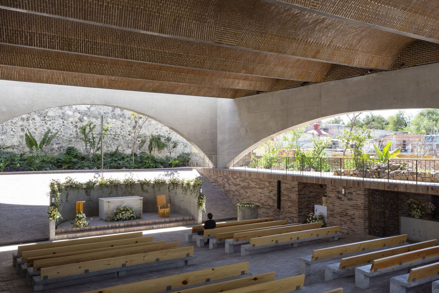 Interior of Señor de Tula Sanctuary showing the brick-vaulted ceiling supported by concrete arches, with wooden pews facing a simple altar (Photo: Dellekamp Schleich + AGENdA Agencia de Arquitectura)