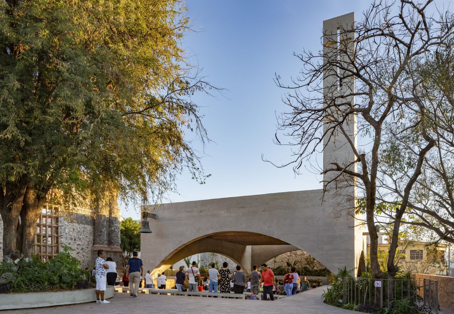 Community gathering at the exterior of the sanctuary, where concrete arches create a threshold space between inside and outside (Photo: Dellekamp Schleich + AGENdA Agencia de Arquitectura)