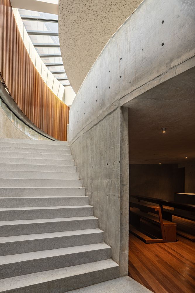 Stairway leading from the half-sunken nave to the ground level, illustrating the gradual transition between the interior sacred space and the outside world (Photo: ARQBR Arquitetura e Urbanismo)
