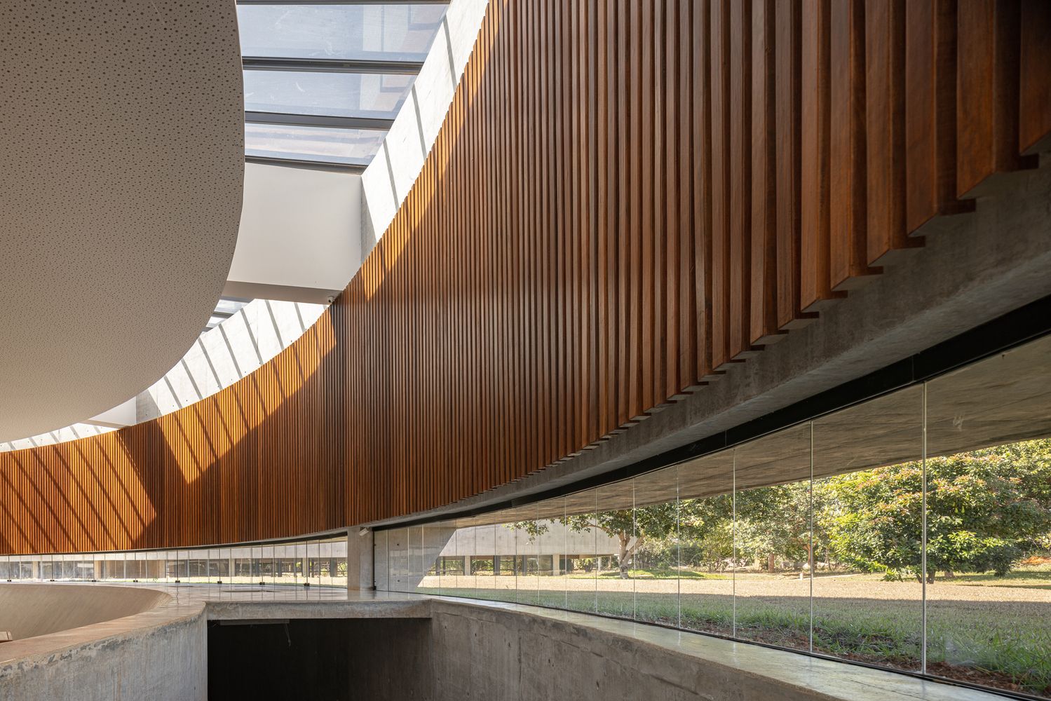 The horizontal glass opening that encircles the nave, demonstrating how the sunken floor allows views of the surrounding landscape while maintaining interior privacy (Photo: ARQBR Arquitetura e Urbanismo)