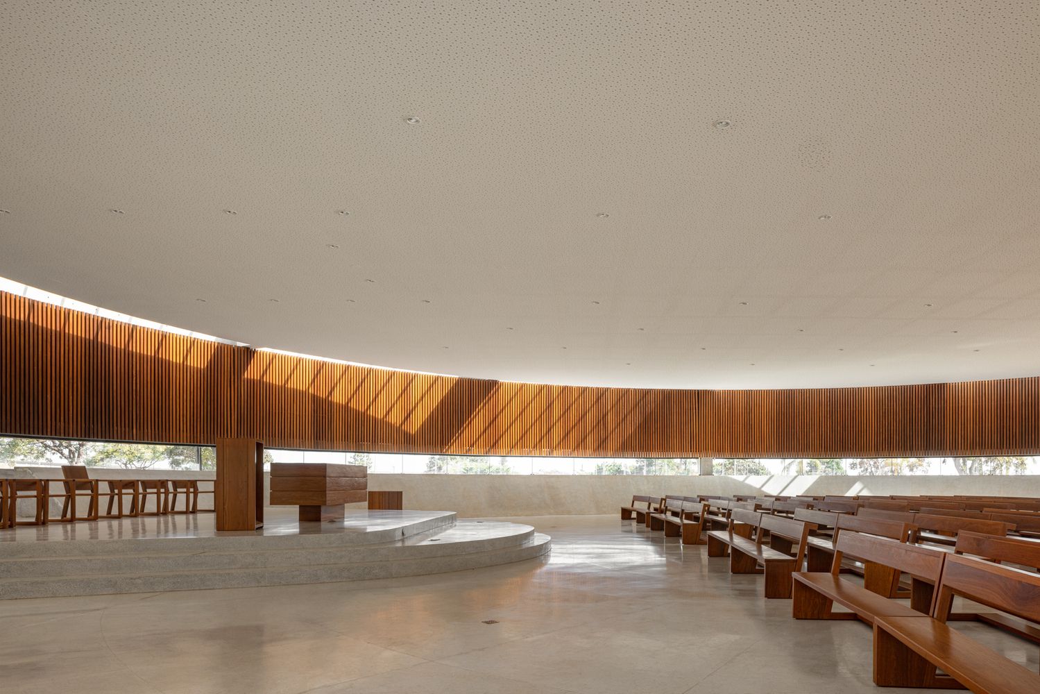 View of the altar area with natural light washing across the circular space from the perimeter windows and overhead skylight(Photo: ARQBR Arquitetura e Urbanismo)