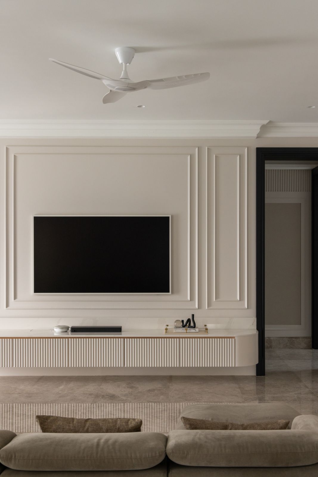 Refined formal living room with a sophisticated TV wall installation
