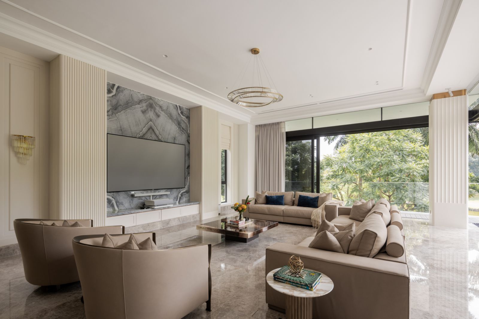 The formal living room overlooks the pool, featuring elegant furnishings, architectural detailing and strategic lighting with views of the surrounding golf park landscape