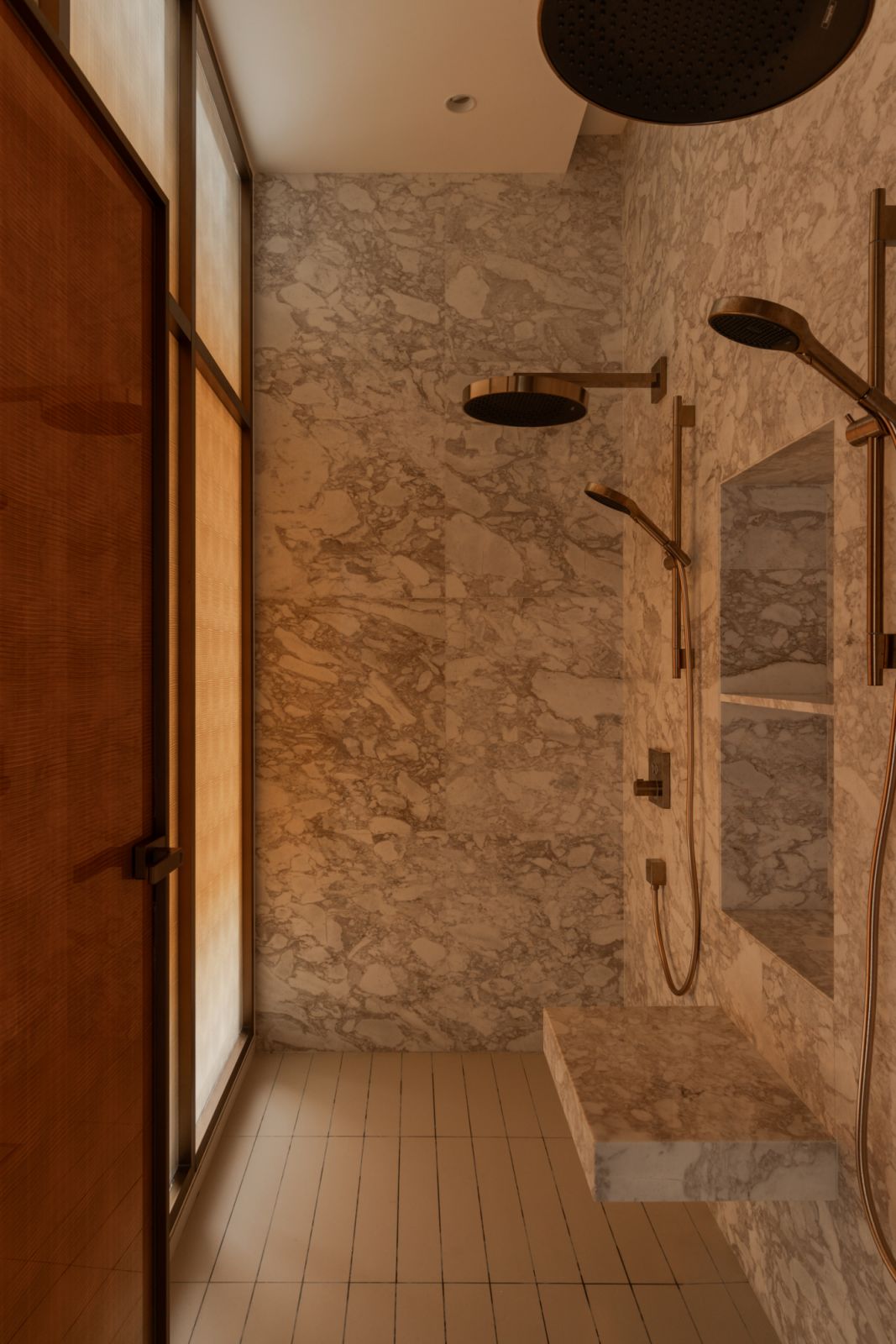 Sophisticated master bathroom featuring warm copper accents against luxurious marble surfaces