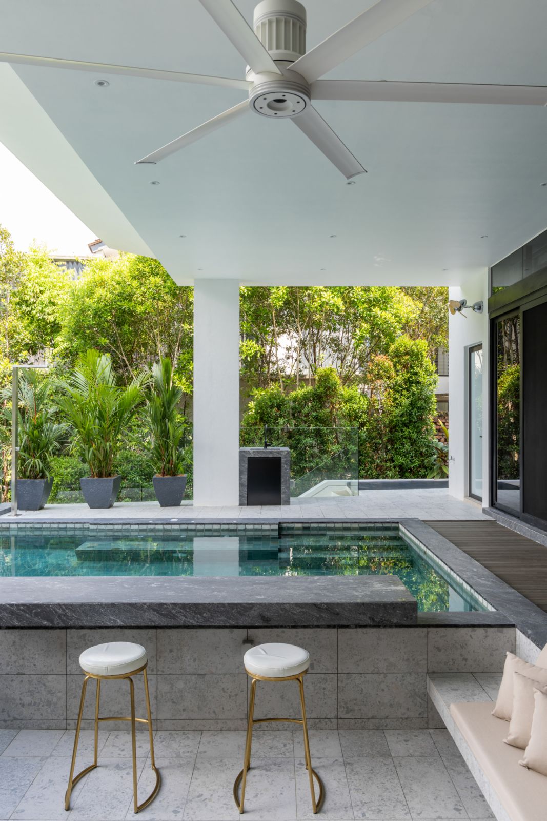 The outdoor pool with distinctive Sukabumi green tiles extends toward the golf park greenery,