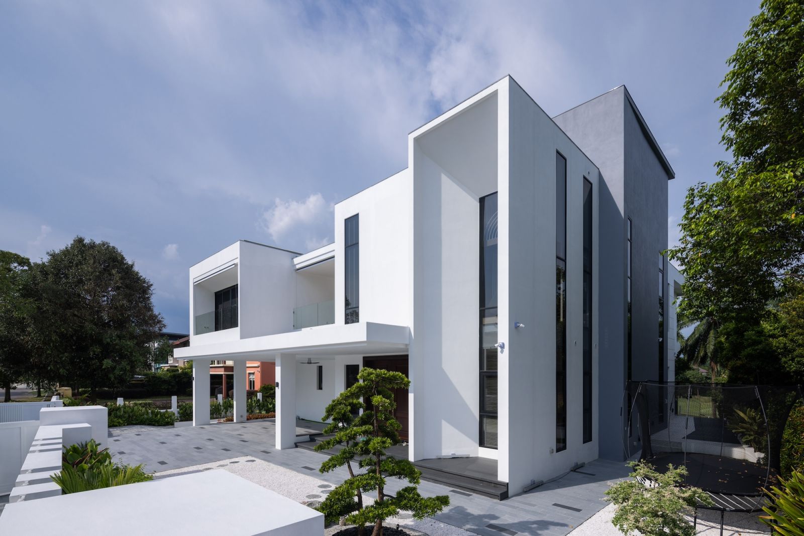 Modern luxury bungalow exterior showcasing distinctive volumetric architecture and carefully curated landscaping elements.