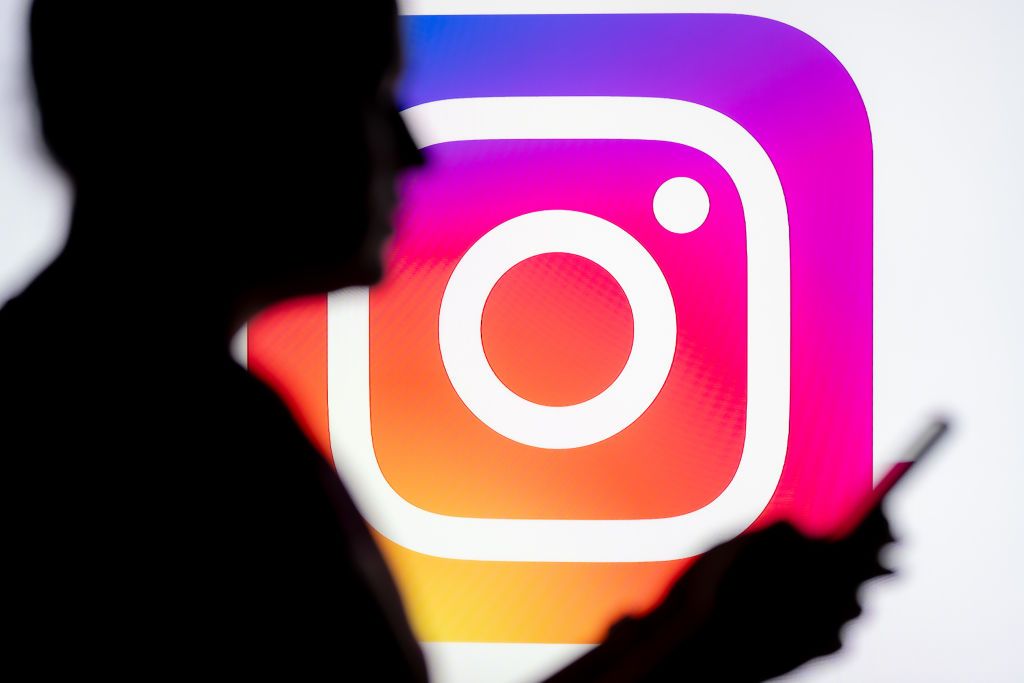 POLAND - 2025/03/07: In this photo illustration, a woman seen looking at a smartphone with an Instagram logo displayed in the background. (Photo Illustration by Mateusz Slodkowski/SOPA Images/LightRocket via Getty Images)