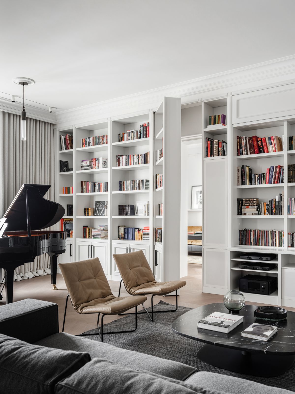 The library area in the living room of this Moscow apartment is complete with a hidden bookshelf door that leads to a quiet office (Photo: Mikhail Loskutov)