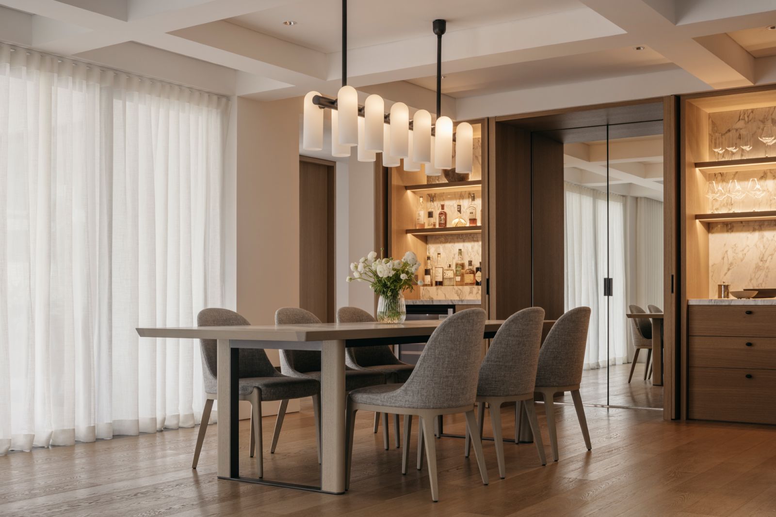 A closer view of the pantry, with the cabinets revealed and illuminated, plus the mirrored kitchen entrance at the centre