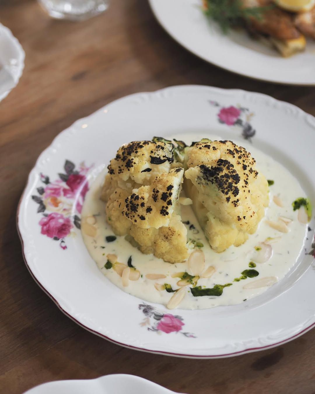 Roasted Cauliflower ดอกกะหล่ำอบเนื้อนุ่มเสิร์ฟกับซอสครีม อัลมอนด์สไลซ์ และน้ำมันสมุนไพร เมนู Zero waste จากร้าน Et 1.5 (ภาพ: Instagram / @et1.5_th)
