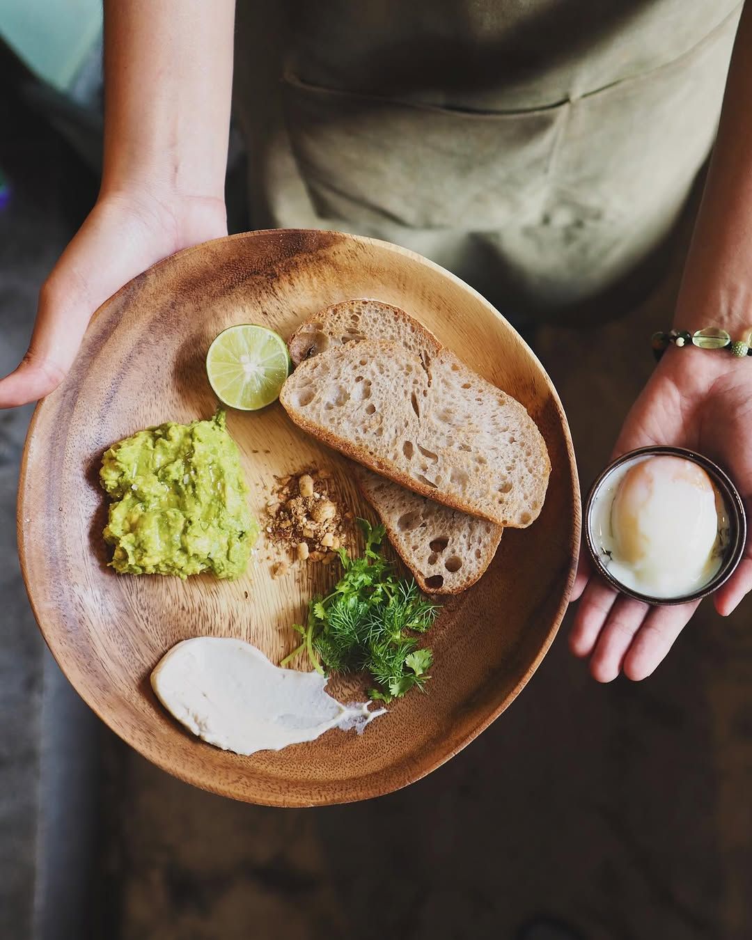 Avocado Toast Separate อะโวคาโดโทสต์เสิร์ฟแบบแยกส่วน เสิร์ฟอะโวคาโดบดปรุงรสด้วยเกลือฮากาตะ บนขนมปังซาวร์โดว์กรอบนอกนุ่มใน พร้อมครีมจากเม็ดมะม่วงหิมพานต์ ท็อปด้วยชเครื่องเทศถั่วบดสไตล์ตะวันออกกลาง และสมุนไพรสด คู่กับไข่ต้มยางมะตูม จากร้าน Hugs Songwat (ภาพ: Instagram / @hugs.songwat)