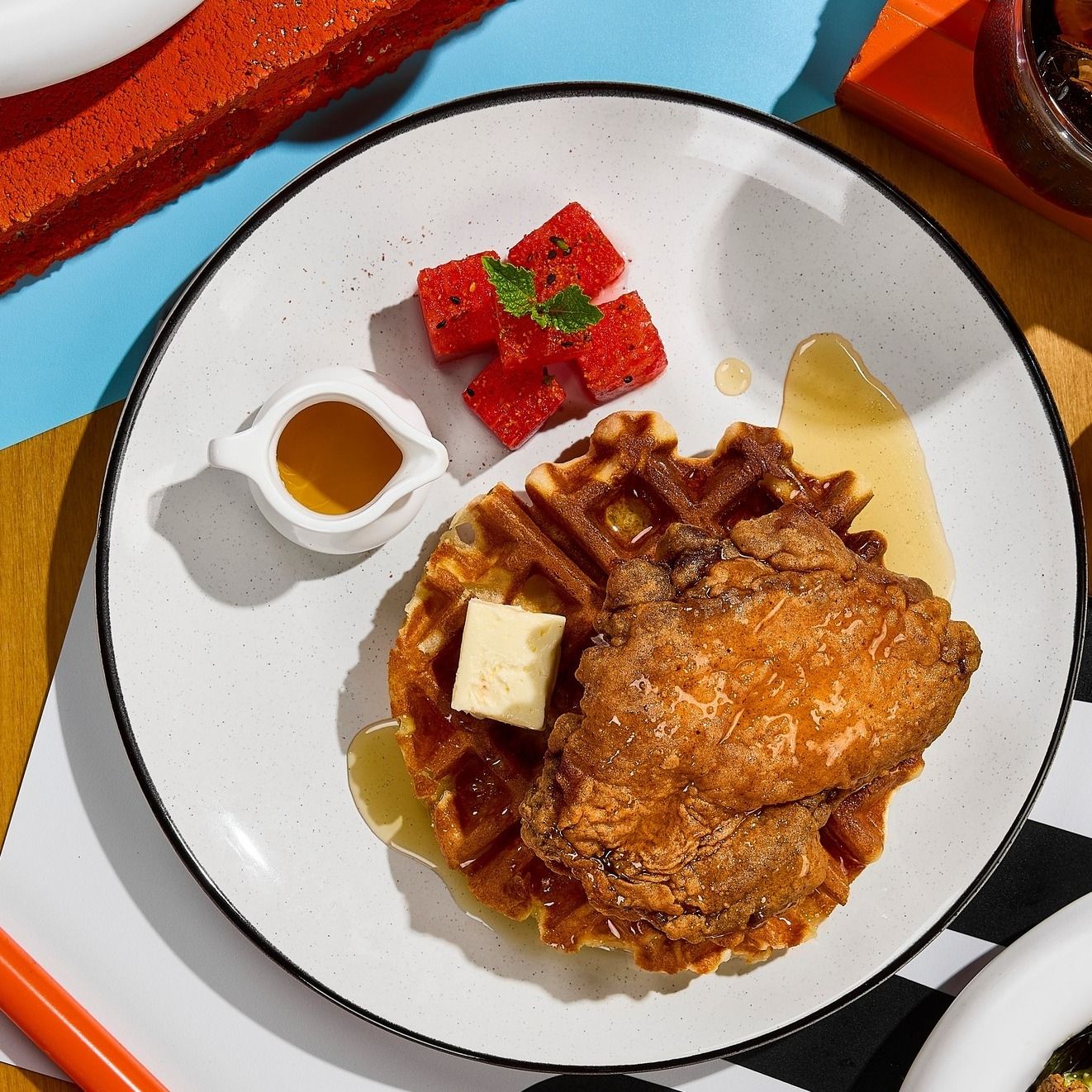 Fried Chicken with Mochi Waffle ไก่ทอดสูตรซิกเนเจอร์เสิร์ฟคู่กับวาฟเฟิลโมจิเนื้อนุ่มหนึบ ที่นำความคลาสสิกของไก่ทอดมาผสานกับเท็กซ์เจอร์แสนสนุกของวาฟเฟิลสไตล์ญี่ปุ่น เสิร์ฟพร้อมแตงโมหมักส้ม ให้รสเปรี้ยวหวานสดชื่นจากร้าน Halfway Brunch & Roastery (ภาพ: Instagram / @halfway.bkk)
