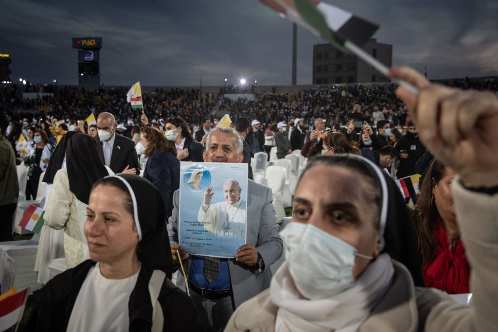 People celebrate and wave flags after the completion of a mass conducted by Pope Francis at the Franso Hariri Stadium on March 07, 2021 in Erbil, Iraq. Pope Francis arrived in Erbil, the final stop of his historic four-day visit, the first ever papal visit to Iraq (Photo by Chris McGrath/Getty Images)