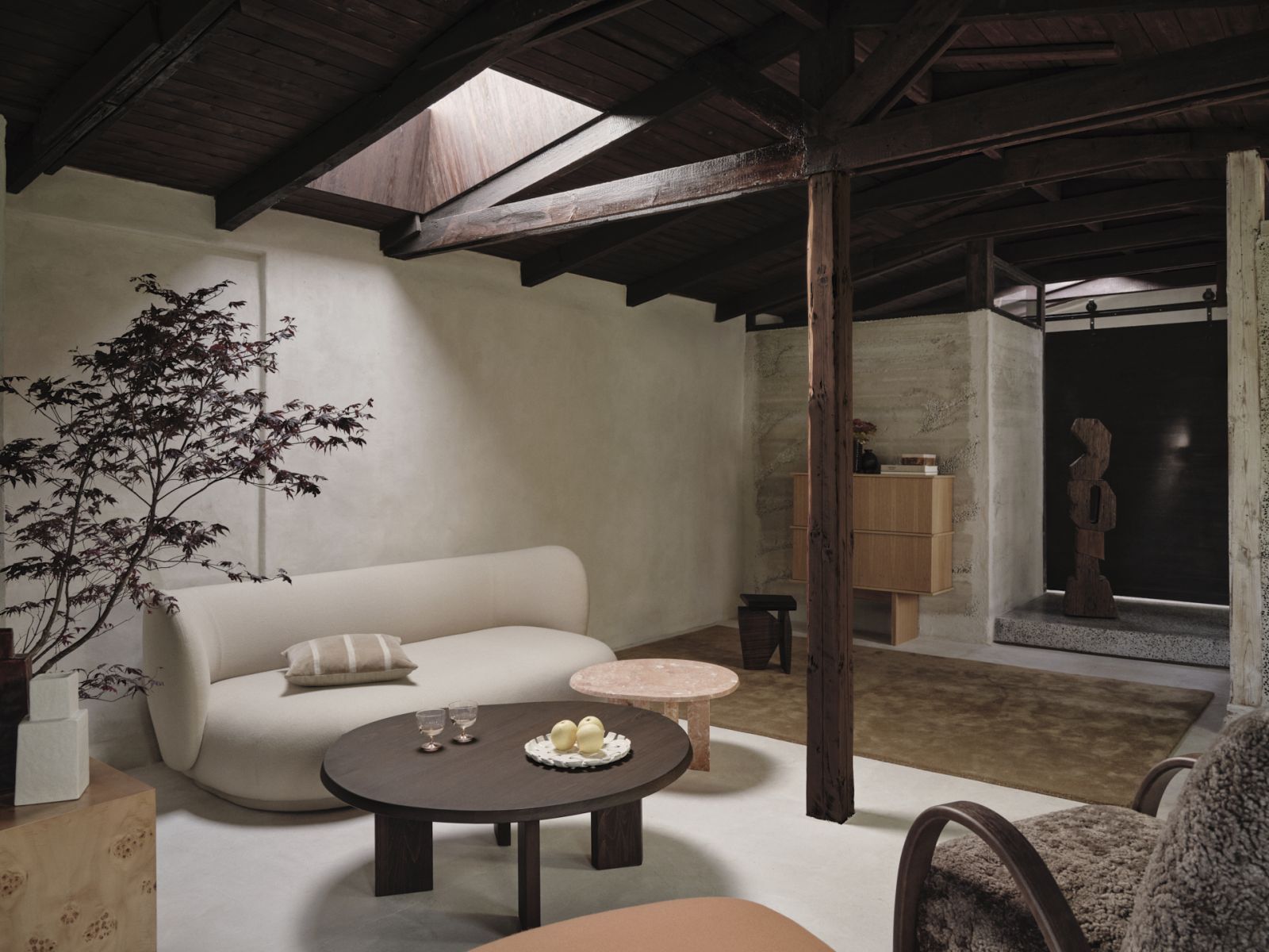 The contrast between exposed wooden beams and smooth plastered walls illustrates warm minimalism’s appreciation for material honesty (Photo: Fermliving)