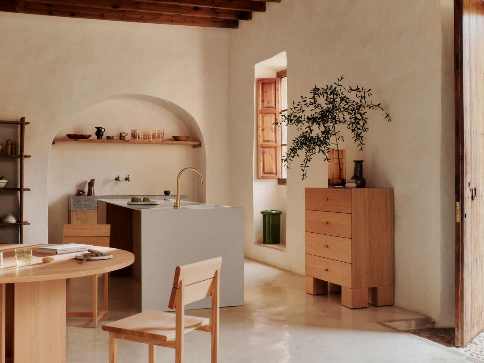 A kitchen space exemplifying warm minimalism’s core principles: tactile materials, organic forms, and restrained decoration (Photo: Fermliving)