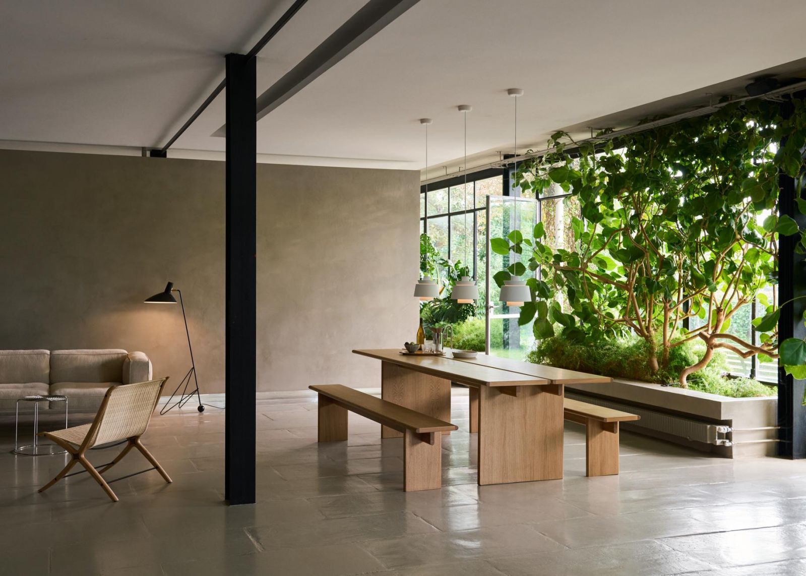 Warm minimalist dining area where natural light and biophilic elements create harmony with simple wooden furnishings (Photo:&Tradition)