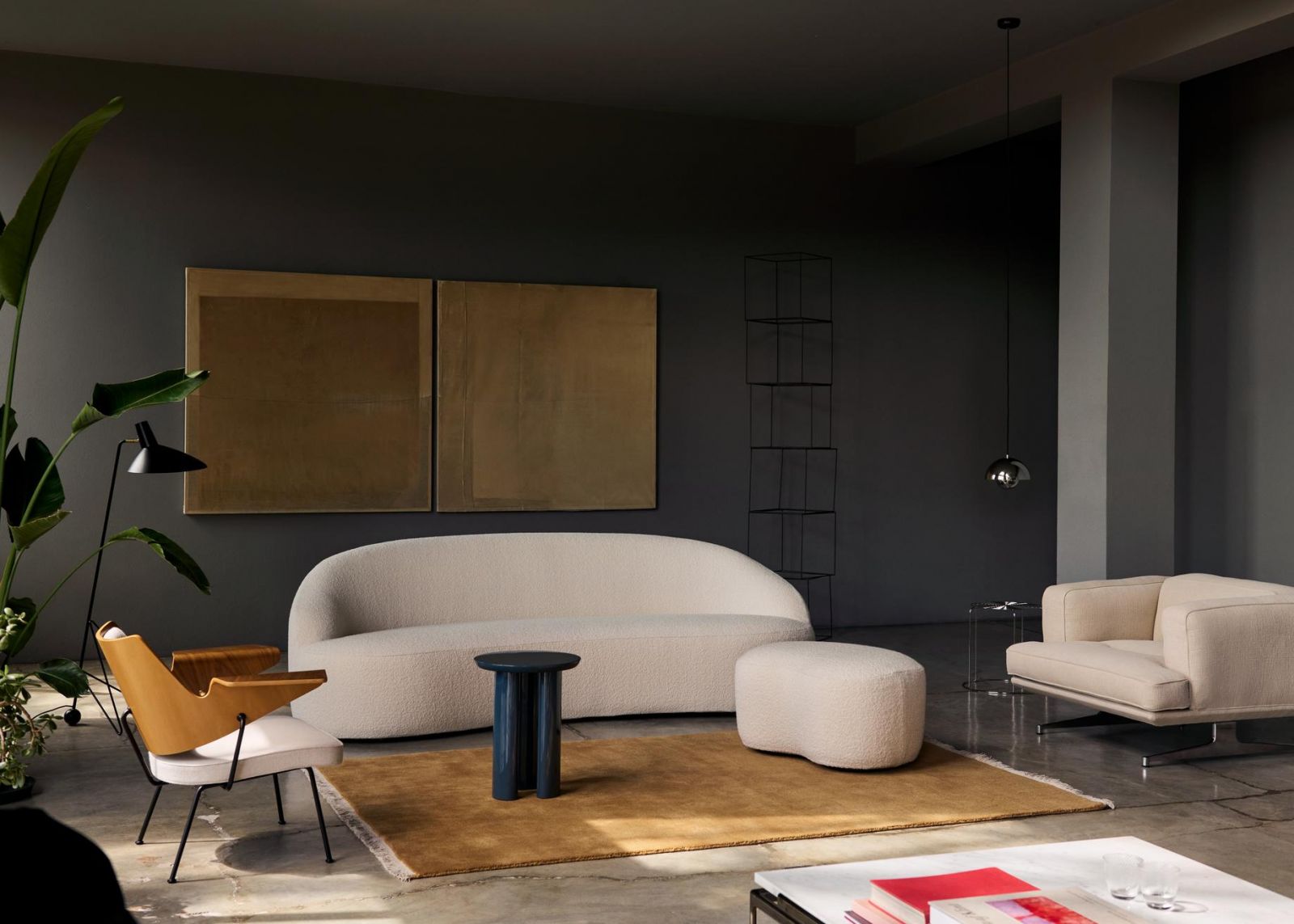 The careful juxtaposition of textures—from the nubby fabric to the smooth wooden panels and metallic accents—demonstrates how material contrast can create visual richness without requiring decorative excess (Photo: &Tradition)