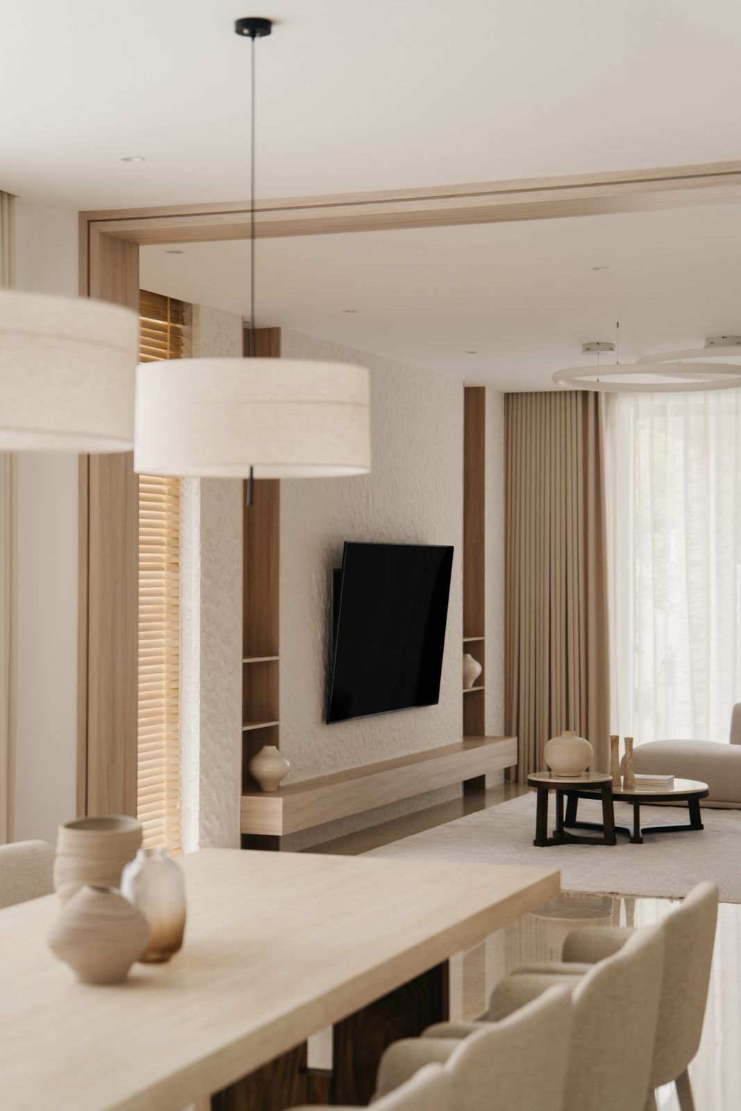 Seamless open-plan living space with textured white feature wall, custom pendant lighting and Aman-inspired furniture selection