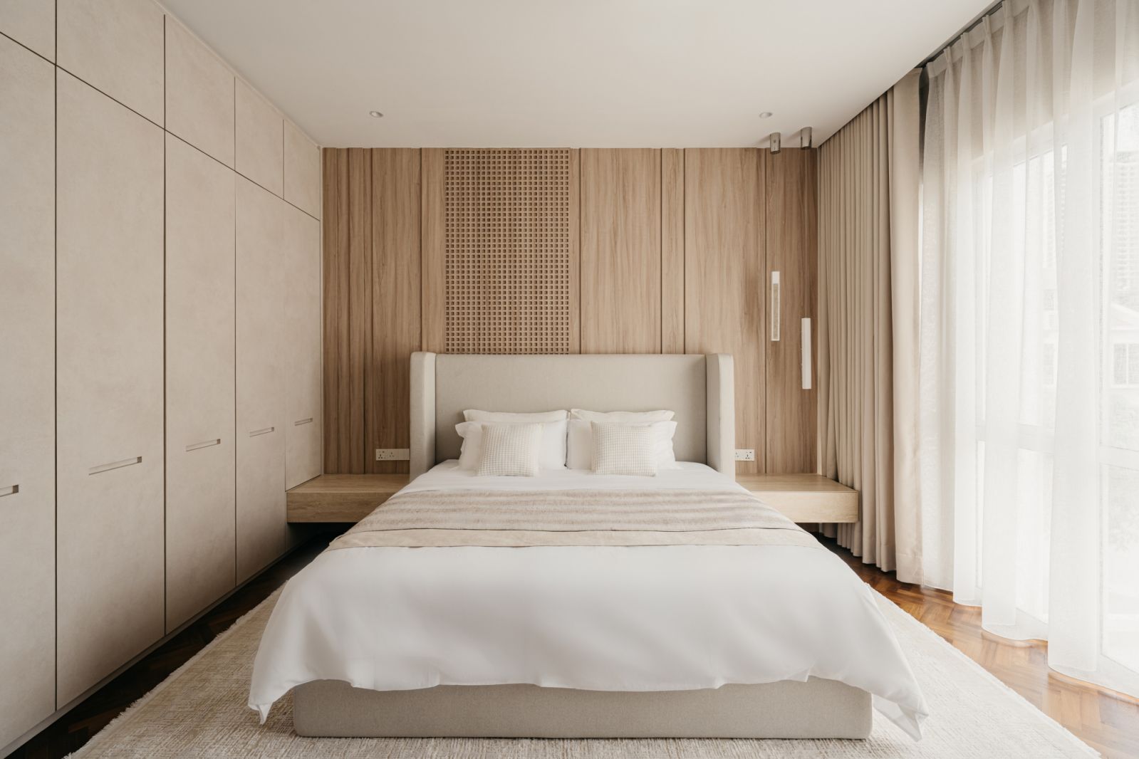 Contemporary bedroom sanctuary with bespoke wood panelling, integrated storage and sheer drapery maximising natural light