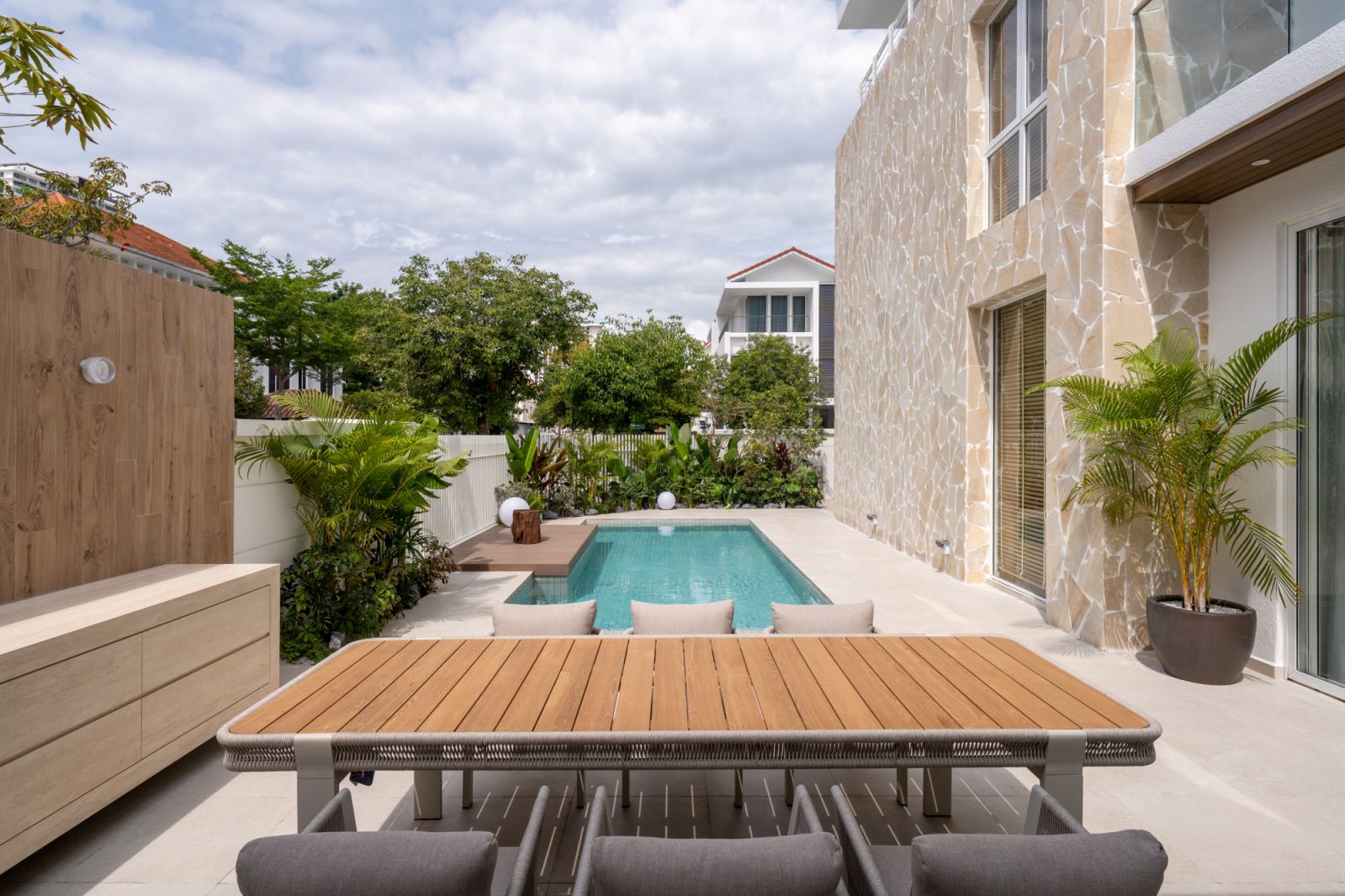 The pool terrace with integrated wooden deck and Sputnik Forest tropical landscaping