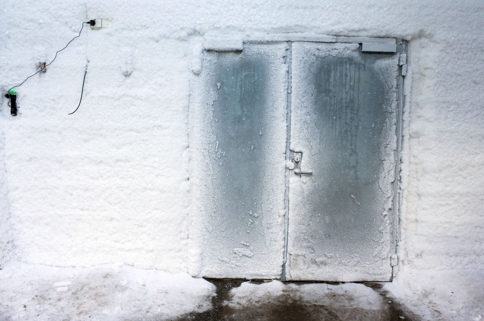 An iced entrance door to the international gene bank Svalbard Global Seed Vault (SGSV) near Longyearbyen on Spitsbergen, Norway, 08 April 2015. During permafrost, the germs of more than four million plants such as rice, corn, beans, and potatoes are collected, frozen, and secured for the future in three mountain caves. Photo: Jens Büttner | usage worldwide (Photo by Jens Büttner/picture alliance via Getty Images)