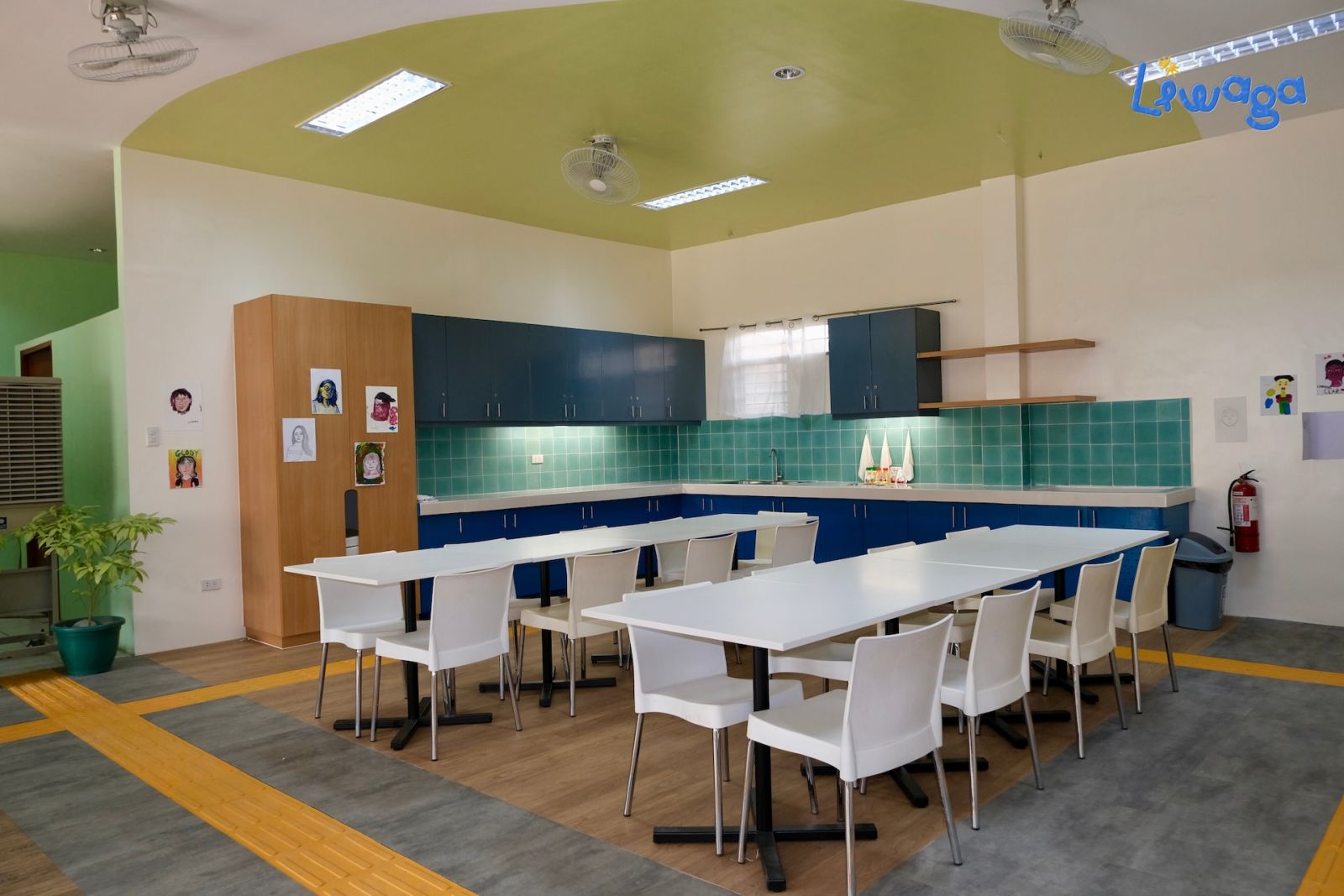 The renovated boys' dormitory in Hospicio de San Jose, now boasts a clean and calm ambiance with creamy white walls, a departure from the previous green. The mini kitchen area has been transformed with cool-toned cabinets, curvilinear openings for easy access after a redesign by Benilde interior design students