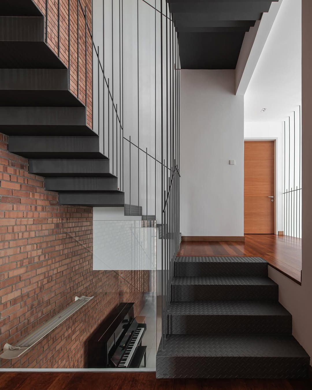 The folded steel plate staircase hanging from above on steel rods (Photo: David Yeow Photography)