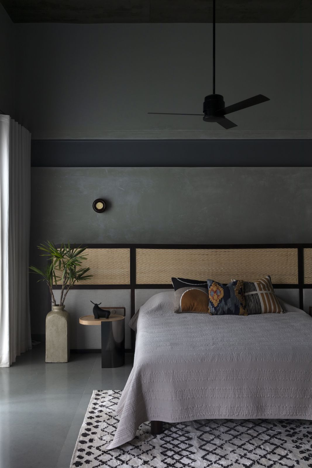A bedroom with a moody colour palette in a summer home in Hyderabad, India