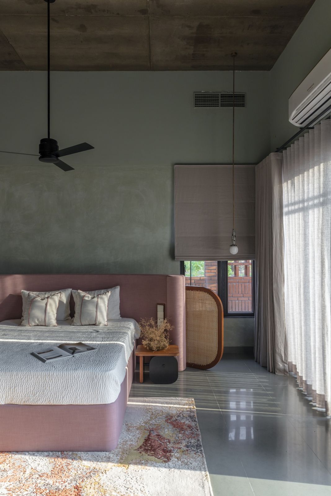 A bedroom with a moody colour palette in a summer home in Hyderabad, India
