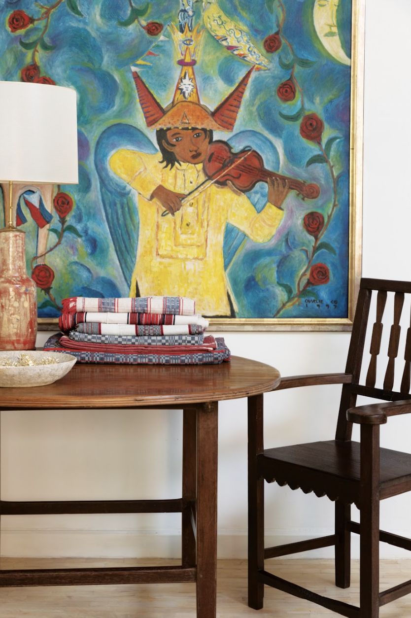 Wilson's guest room features a 1997 Charlie Co painting, After 100 Years, reflecting on a century since Aguinaldo declared independence from Spain. In front of the painting is a narra and balayong round table with antique Ilocano inabel blankets, flanked by a balayong armchair from Batangas (Photo: Jinggo Montenejo)