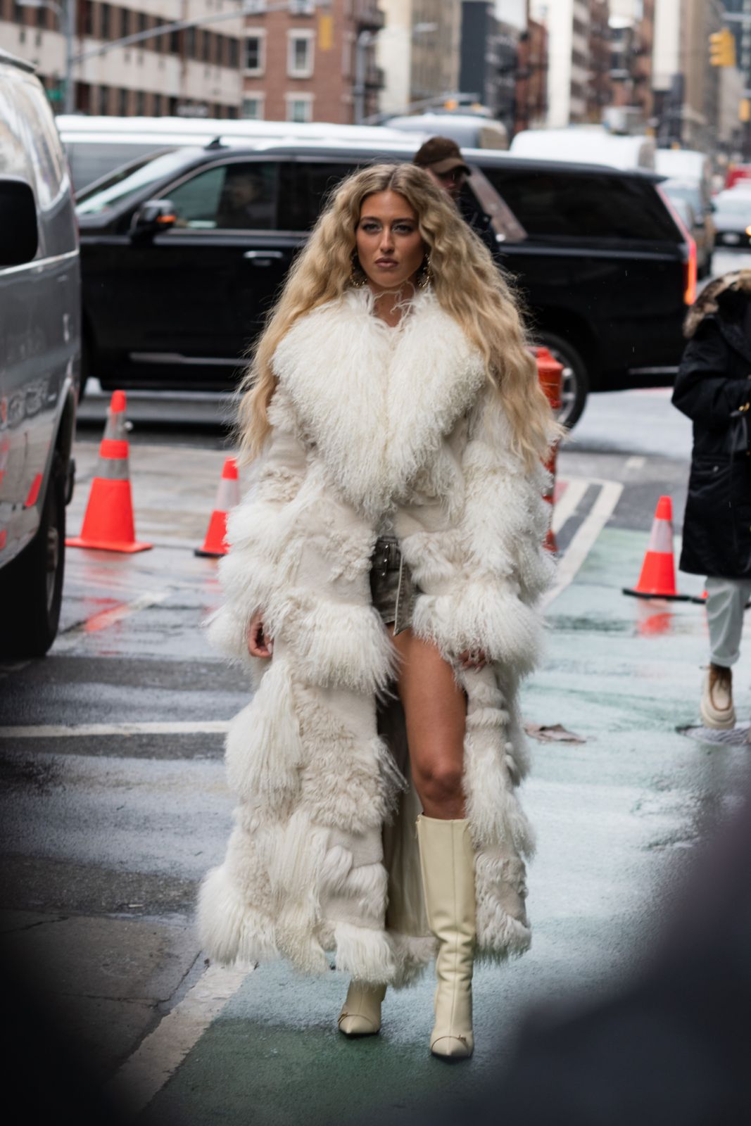 NEW YORK, NEW YORK - FEBRUARY 13: A guest is seen wearing a cream coat, green skirt and cream boots outside the Michael Kors show during February 2024 New York Fashion Week on February 13, 2024 in New York City. (Photo by Jade Tillman Belmes/Getty Images)