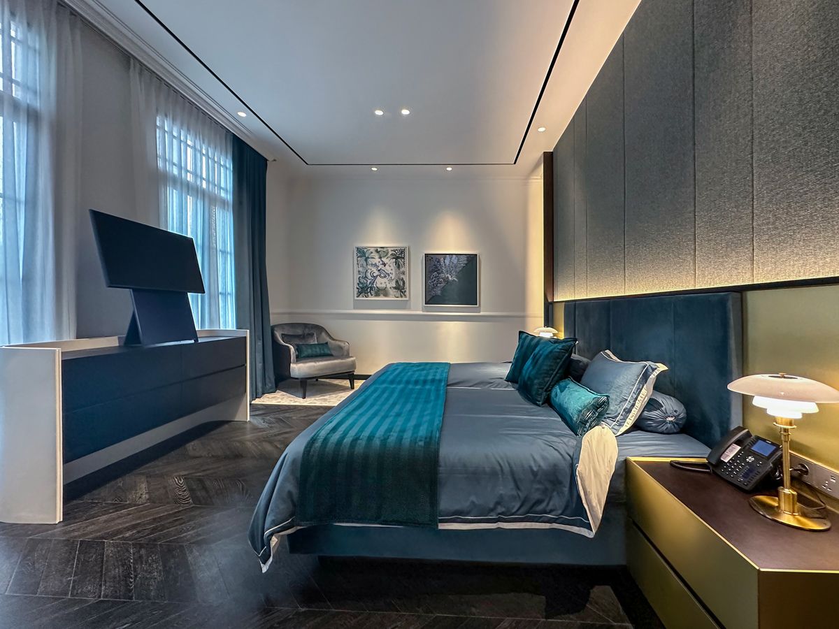 Deep teal tones foster relaxation in the landed home's master bedroom, which also features a compact, rotatable TV