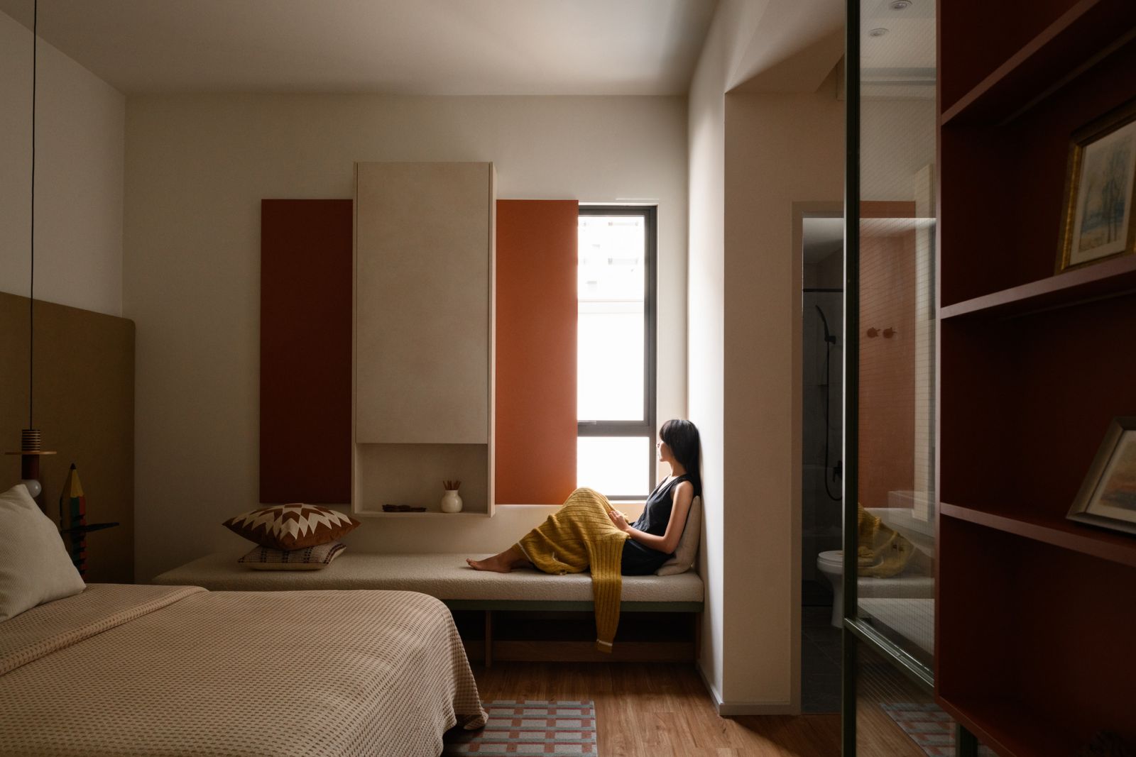 The serene bedroom features a reading nook by the window where the homeowner finds quiet moments with a book