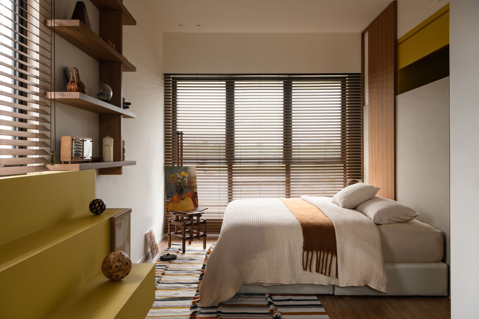 Clever built-in storage with yellow accents transforms this bedroom into a tranquil sanctuary while maximising space in the renovated terrace house