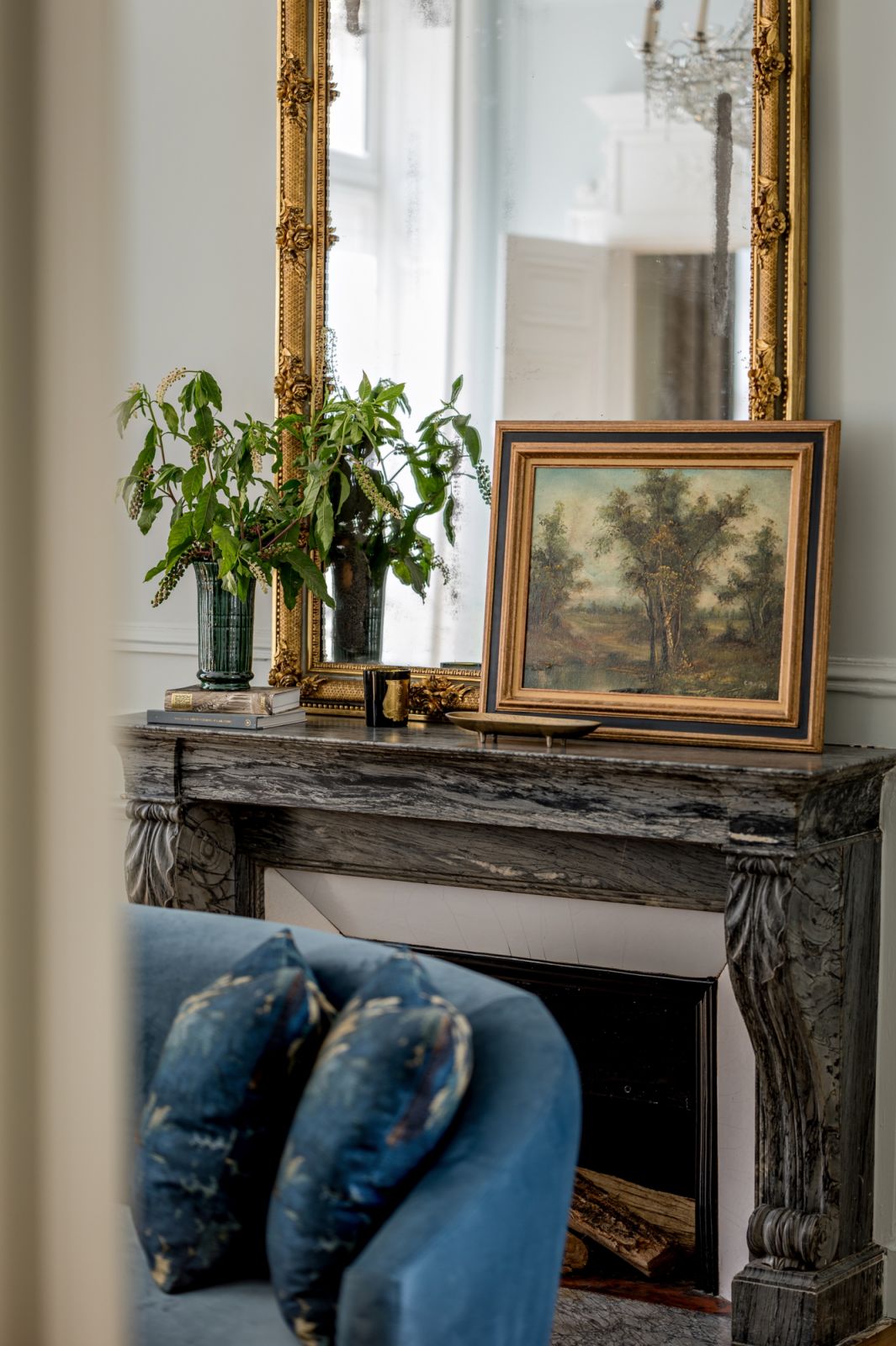 The carved gilded mirror atop the fireplace